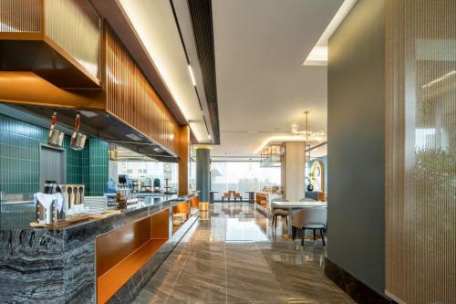 a kitchen with a counter and a dining room at Yujian Meihao Hotel in Xingsha