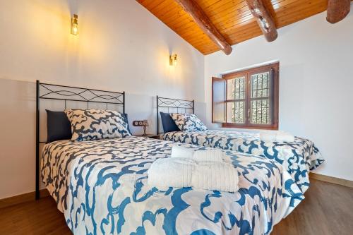 a bedroom with two beds and a wooden ceiling at La Casa Gran Clariana in Gornal