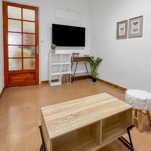 un salon avec une télévision et une table dans l'établissement Charmant T2, Idéal pour explorer Perpignan à pied, à Perpignan