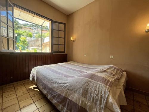 une chambre avec un lit et une grande fenêtre dans l'établissement Maison de pêcheurs, Saint-Mandrier-sur-Mer, climatisation, vue mer, à Saint-Mandrier-sur-Mer