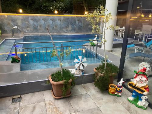 a swimming pool with some plants and animals next to it at La Bella Suit Otel in Kusadası