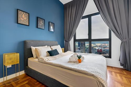 a bedroom with blue walls and a bed with a window at Luxury Suites At The Mews KLCC in Kuala Lumpur