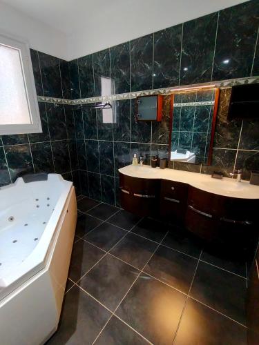 a bathroom with a tub and two sinks and a bath tub at Villa Beata in Perama