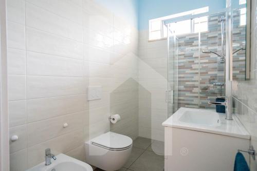 a white bathroom with a toilet and a sink at Homiday - Appartamento Rosy in Pineto