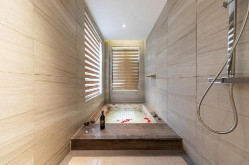 a bathroom with a bath tub with a shower at Avatar Peaks Resort in Zhangjiajie
