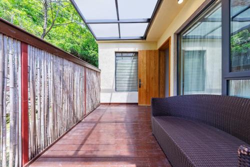 a balcony with a couch and a glass door at Avatar Peaks Resort in Zhangjiajie