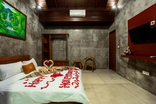 a bedroom with a bed with red flowers on it at Om Villas Kedungu in Tanah Lot