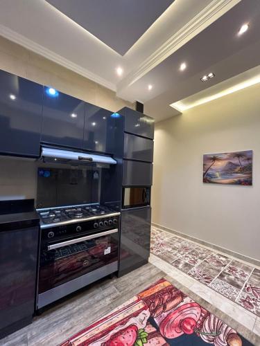 开罗Modern 3-BR in New Cairo Lotus的厨房配有炉灶,墙上挂有绘画作品
