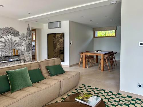 un salon avec un canapé et une table dans l'établissement Appartement à 100mètres du lac avec terrasse privée - Vue panoramique sur le lac, à Sévrier