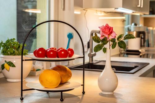 a table with two plates of fruit and a vase with a rose at Gästezimmer Cleo in Uhldingen-Mühlhofen
