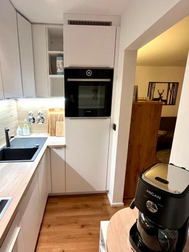 a kitchen with a black and white appliance at Bergchalet mit Pool und Sauna in Missen-Wilhams