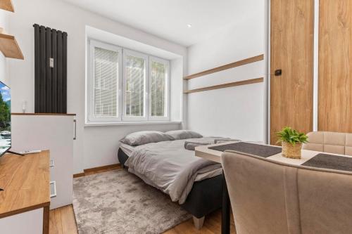 布拉迪斯拉发AH Belehradská的一间卧室，配有一张床、一张桌子和一张书桌