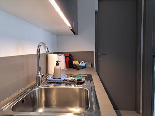 a kitchen counter with a sink and a stove at Urban Residence by Quokka 360 - Apartments with parking in Lugano in Aldesago