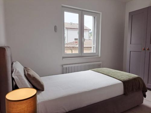 a white bedroom with a bed and a window at Urban Residence by Quokka 360 - Apartments with parking in Lugano in Aldesago