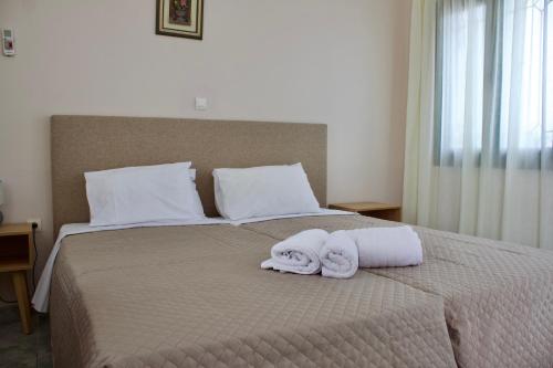 a bedroom with a bed with towels on it at Niforos Panorama in Vovikes