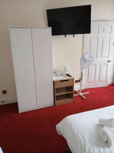 a bedroom with a white closet and a desk with a fan at The Knighton Hotel in Knighton