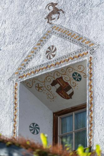 a mirror on the side of a wall with a picture at Hotel Chesa Grischuna in Klosters