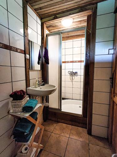 a bathroom with a sink and a shower and a tub at Domek Stojkowo in Stojkowo