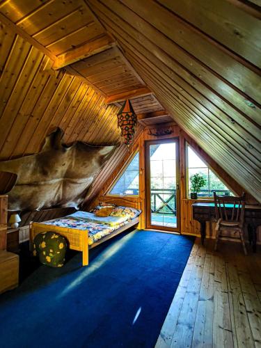 a bedroom with a bed in a wooden cabin at Domek Stojkowo in Stojkowo