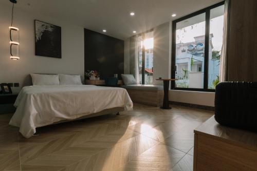 a bedroom with a large bed and a large window at EL Where Hotel in Ho Chi Minh City