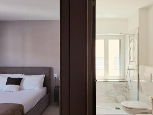 a bedroom with a bed and a glass shower at Urban Residence by Quokka 360 - Apartments with parking in Lugano in Aldesago