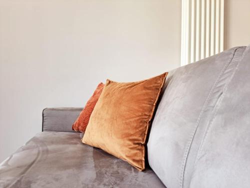 a brown pillow sitting on a gray couch at Urban Residence by Quokka 360 - Apartments with parking in Lugano in Aldesago