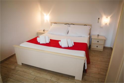 a bedroom with a large white bed with red blanket at Villa Giusi in Tropea