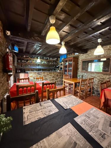 a restaurant with tables and chairs with maps on the tables at La Casona de Faedo Pensión in Faedo