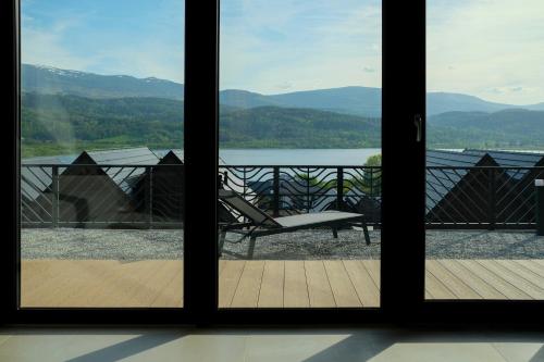 a view from a window of a deck with a chair at Wille w Lake Hill Karkonosze Resort & SPA in Sosnówka