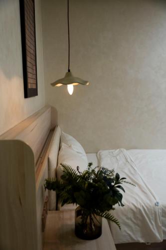 a potted plant sitting on a table next to a bed at EL Where Hotel in Ho Chi Minh City