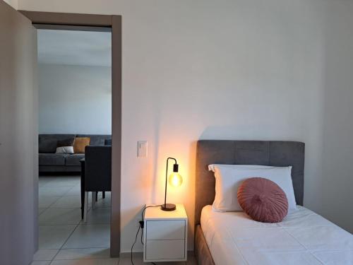 a bedroom with a bed with a lamp and a living room at Urban Residence by Quokka 360 - Apartments with parking in Lugano in Aldesago