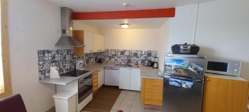 a small kitchen with a refrigerator and a microwave at Reykjanes Apartments in Grindavík