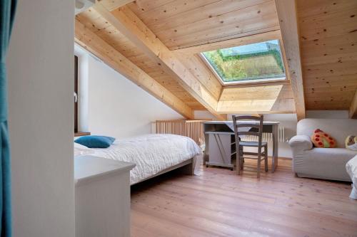 a bedroom with a bed and a desk and a window at Agritur La Gemma in Sant'Orsola Terme