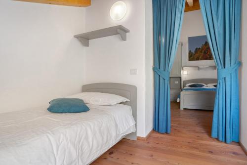 a bedroom with a bed with blue drapes at Agritur La Gemma in Sant'Orsola Terme