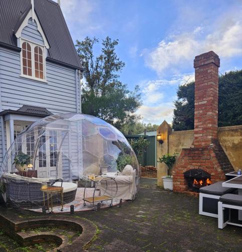 a greenhouse in front of a house with a fireplace at Chateau By The Bay in Kingston Beach
