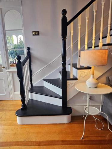 a black and white staircase in a living room with a table at Chateau By The Bay in Kingston Beach