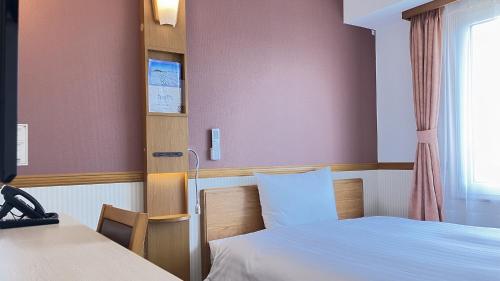 a hospital room with two beds and a window at Toyoko Inn Morioka eki Minami guchi Ekimae in Morioka