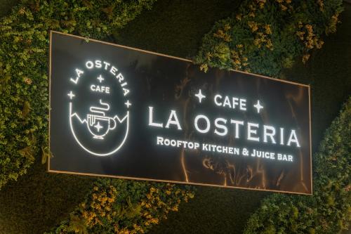 a sign for a cafe la osteria at Stay Studio Hotel & Residences in Gurgaon