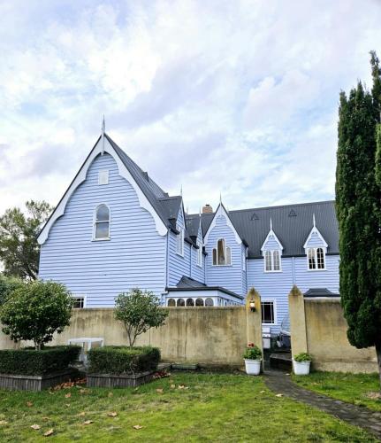 a large blue church with a fence in front of it at Chateau By The Bay in Kingston Beach