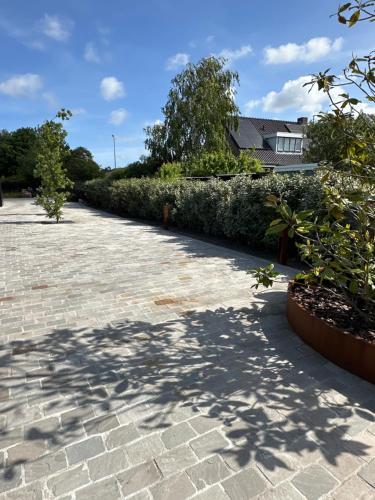 a brick driveway with trees and a house in the background at Suite Ouddorp - 2 pers in Ouddorp