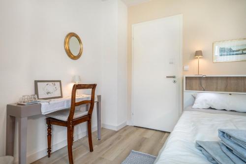 a bedroom with a desk and a bed and a chair at Gästezimmer Cleo in Uhldingen-Mühlhofen