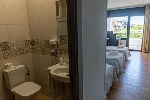 a bathroom with a toilet and a sink in a room at Hotel Planas in Salou