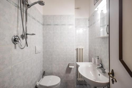 a white bathroom with a toilet and a sink at Family Nest - Tra il Mare, il Centro e il Relax in Misano Adriatico