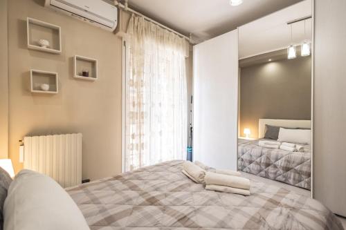 a bedroom with a large bed and a mirror at Family Nest - Tra il Mare, il Centro e il Relax in Misano Adriatico