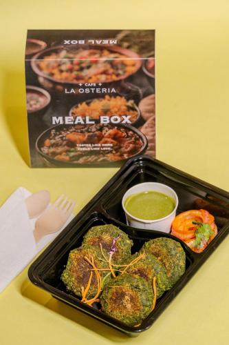 a tray of food with a meal box and sauce at Stay Studio Hotel & Residences in Gurgaon