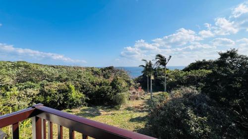 a balcony with a view of the ocean at Retreat House in Yakushima