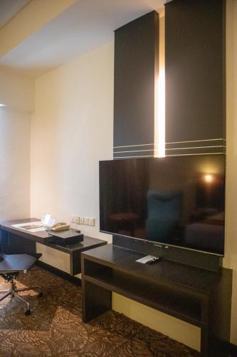 a hotel room with a large television and a desk at The Klagan Hotel in Kota Kinabalu