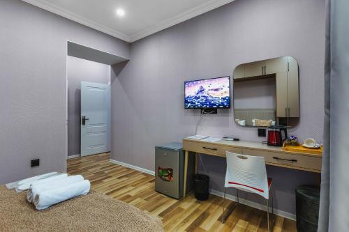 a room with a desk with a computer and a mirror at Hillside Boutique Hotel Baku in Baku