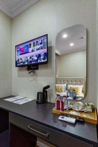 a room with a desk with a tv on the wall at Hillside Boutique Hotel Baku in Baku