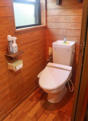 a bathroom with a white toilet in a wooden room at Retreat House in Yakushima